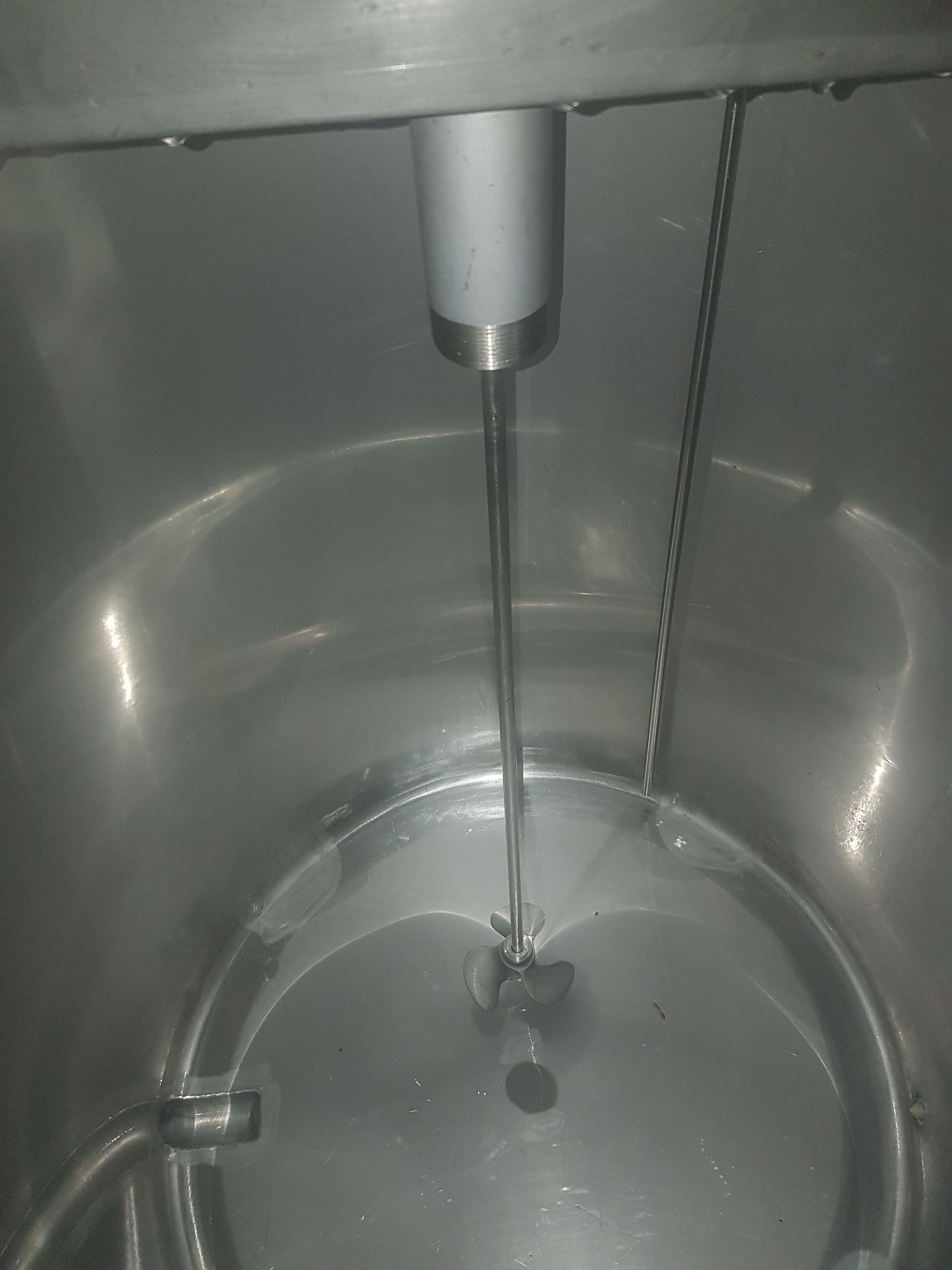 Impellers mixing inside a stainless steel drum.